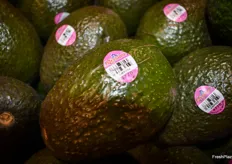 Supporting Breast Cancer Awareness Month with pink labels on avocados.